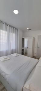 1 dormitorio blanco con 1 cama grande con sábanas blancas en APTO TANEZ LAS VEGAS STYLE, a, en Madrid