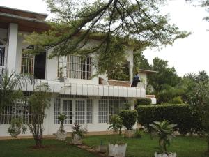 Ein Mann, der auf dem Balkon eines Hauses sitzt. in der Unterkunft Kiriri Residence Hotel in Bujumbura