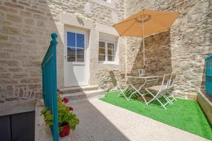 patio ze stołem i parasolem w obiekcie Gîte le Champenois w mieście Balnot-sur-Laignes