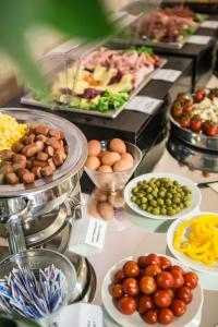un buffet lleno de diferentes tipos de comida en los platos en Hotel Mirage, en Florencia
