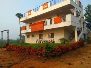 a building with red flowers in front of it at Green Peace Bheemeshwari in Halgūr