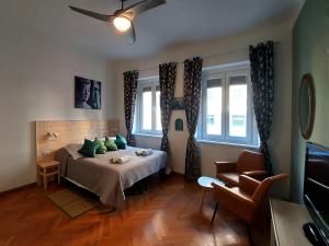Zimmer mit einem Bett, einem Sofa und zwei Fenstern in der Unterkunft Bed & Chic bed & breakfast in Triest