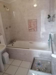 a bathroom with a tub and a toilet and a sink at 36 Mount Road Guesthouse and Self Catering in Port Elizabeth
