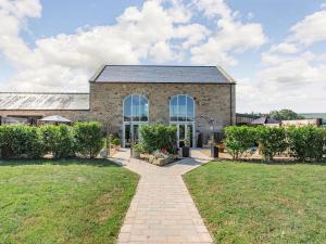 a brick building with a pathway in front of a yard at The Granary - Uk40457 in Newsham