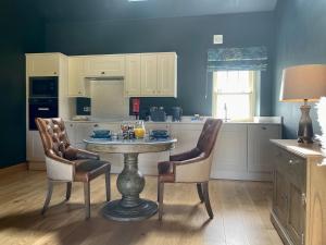 uma cozinha com uma mesa e duas cadeiras e um balcão em The Granary - Uk40457 em Newsham