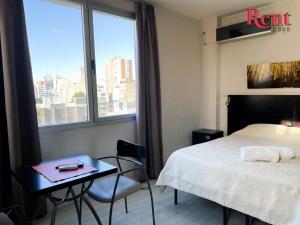 Habitación de hotel con cama, mesa y ventana en Rent2888 Italiano en Buenos Aires