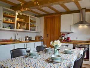 a dining room table with chairs and a tablecloth on it at Cowford Oast in Mark Cross