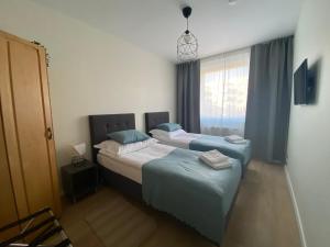 1 dormitorio con 2 camas y ventana en Wrocław Premium Apartment 4You, en Wroclaw