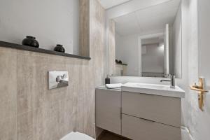 un baño con lavabo y espejo en Odinn Reykjavik Eiriksgata Apartments, en Reikiavik 30 fotos más