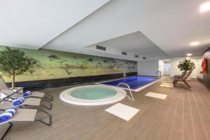 una habitación con una piscina con un cuadro en la pared en Melia Setubal, en Setúbal