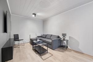 ein Wohnzimmer mit einem Sofa und einem Tisch in der Unterkunft Odinn Reykjavik Eiriksgata Apartments in Reykjavík