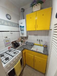a kitchen with yellow cabinets and a stove at DESCANSO IDEAL III Casino, playa y shopping in Mar del Plata