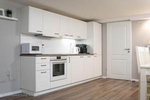 a white kitchen with white cabinets and appliances at Ferienwohnung Schröder in Barntrup