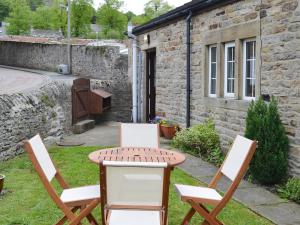 two chairs and a table in a yard at The Butts Cottage in Stanhope