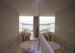 a bathroom with two sinks and a large window at Otantus Hotel in Muros