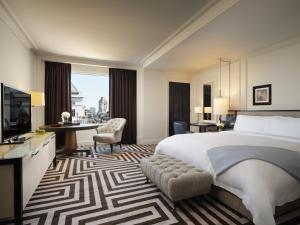 una camera d'albergo con un grande letto e una scrivania di Rosewood London a Londra