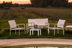 3 sillas blancas, mesa, mesa y sillas en Old Villas Greco 1888 luxury swimming pool, en Cutrofiano