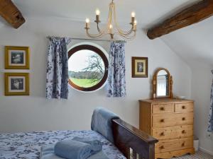 a bedroom with a bed and a round window at The Beehive in Betley