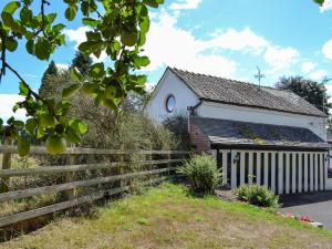 an old house with a fence in front of it at The Beehive in Betley