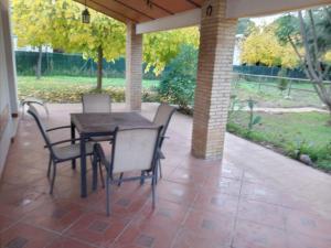 porche con mesa y sillas en el patio en Cortijo Los Conquistadores, en Lucena del Puerto