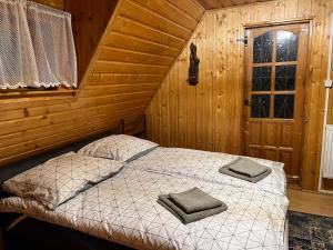 um quarto com uma cama num chalé de madeira em Orzechowy Zakątek em Zbiczno