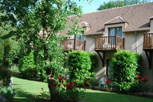 una casa con balcones y un patio con rosas rojas en Domaine de L'Arbrelle, en Amboise