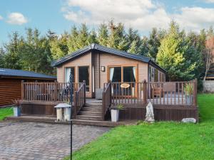 a tiny house with a deck and stairs at Griffon Lodge - Uk3469 in Felton