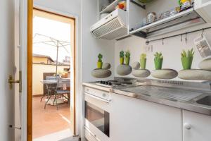 uma cozinha com armários brancos e plantas no balcão em Panoramic lovely time em Siena