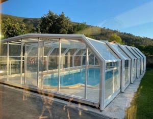 a glass greenhouse with a swimming pool in it at Casa con piscina en el corazón de Cantabria. in Cos