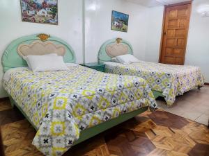a bedroom with two beds and a door at Hotel Altamira Suites - Ibarra in Ibarra