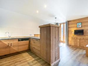 a large kitchen with wooden cabinets and a sink at Appartement La Clusaz, 3 pièces, 8 personnes - FR-1-437-25 in La Clusaz