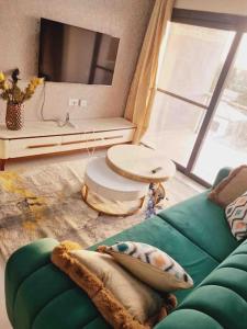 uma sala de estar com um sofá verde e uma televisão em Modern 1-bed Seaside Flat Bijilo em Sere Kunda