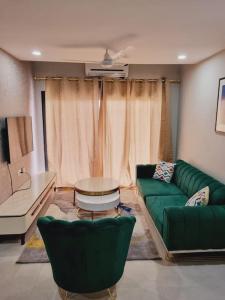 uma sala de estar com um sofá verde e uma mesa em Modern 1-bed Seaside Flat Bijilo em Sere Kunda