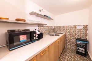cocina con microondas y fregadero en Trastevere Apartment, en Roma