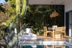 um pátio com uma mesa e cadeiras ao lado de uma piscina em Akwa Resorts Ocean View em Santa Teresa