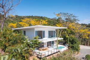 biały dom z basenem i drzewami w obiekcie Akwa Resorts Ocean View w mieście Playa Santa Teresa