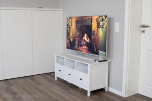 een tv op een wit dressoir in een kamer bij Ferienwohnung Schröder in Barntrup