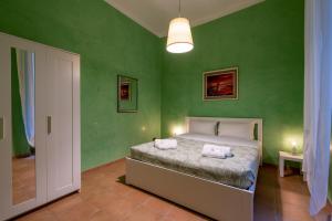 ローマにあるAmpio Appartamento con Vinili in Centro Storicoの緑の壁のベッドルーム1室、ベッド1台(枕2つ付)