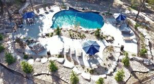 einen Blick über einen Pool mit Stühlen und Sonnenschirmen in der Unterkunft The Bavarian Village Resort in Branson