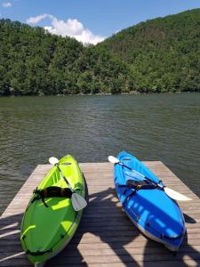 dos kayaks sentados en un muelle en un lago en Casa de pe Lac en Bălana