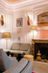 a living room with a couch and a fireplace at Hôtel Vernet Champs Elysées Paris in Paris