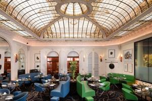 um restaurante com mesas e cadeiras e um tecto de vidro em Hôtel Vernet Champs Elysées Paris em Paris