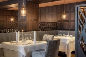 a dining room with two tables and chairs and lights at Stella Hotel - My Dolomites Experience in Selva di Val Gardena