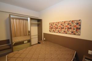 Park Veredas Resort في ريو كوينتي: غرفة نوم بسرير ودهان على الحائط