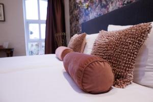 Una cama con almohadas marrones encima. en Mariafarm, en Zevenbergen