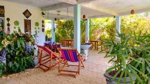een veranda met kleurrijke schommelstoelen en planten bij Modara Ocean Villa in Tangalle