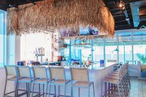 a bar with chairs and a counter in a restaurant at Winter the Dolphin's Beach Club, an Ascend Collection Hotel in Clearwater Beach