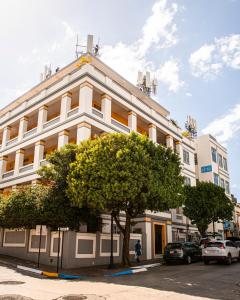 un grande edificio bianco con un albero di fronte di Mayaguez Plaza Hotel; SureStay Collection by Best Western a Mayaguez