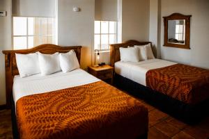 una camera d'albergo con due letti e due finestre di Mayaguez Plaza Hotel; SureStay Collection by Best Western a Mayaguez