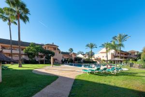 a resort with a swimming pool and palm trees at Penthouse Apartment in Elviria in Marbella